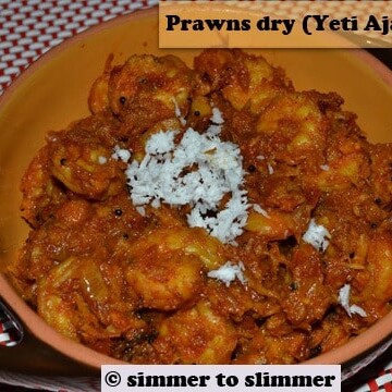 Shrimp / yeti ajadina served in a brown bowl with grated coconut as a garnish.