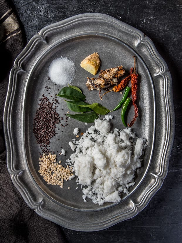 Ingredients used in coconut chutney - grated coconut, green chilies, red chili, tamarind, ginger, salt, curry leaves, mustard seeds, and urad dal