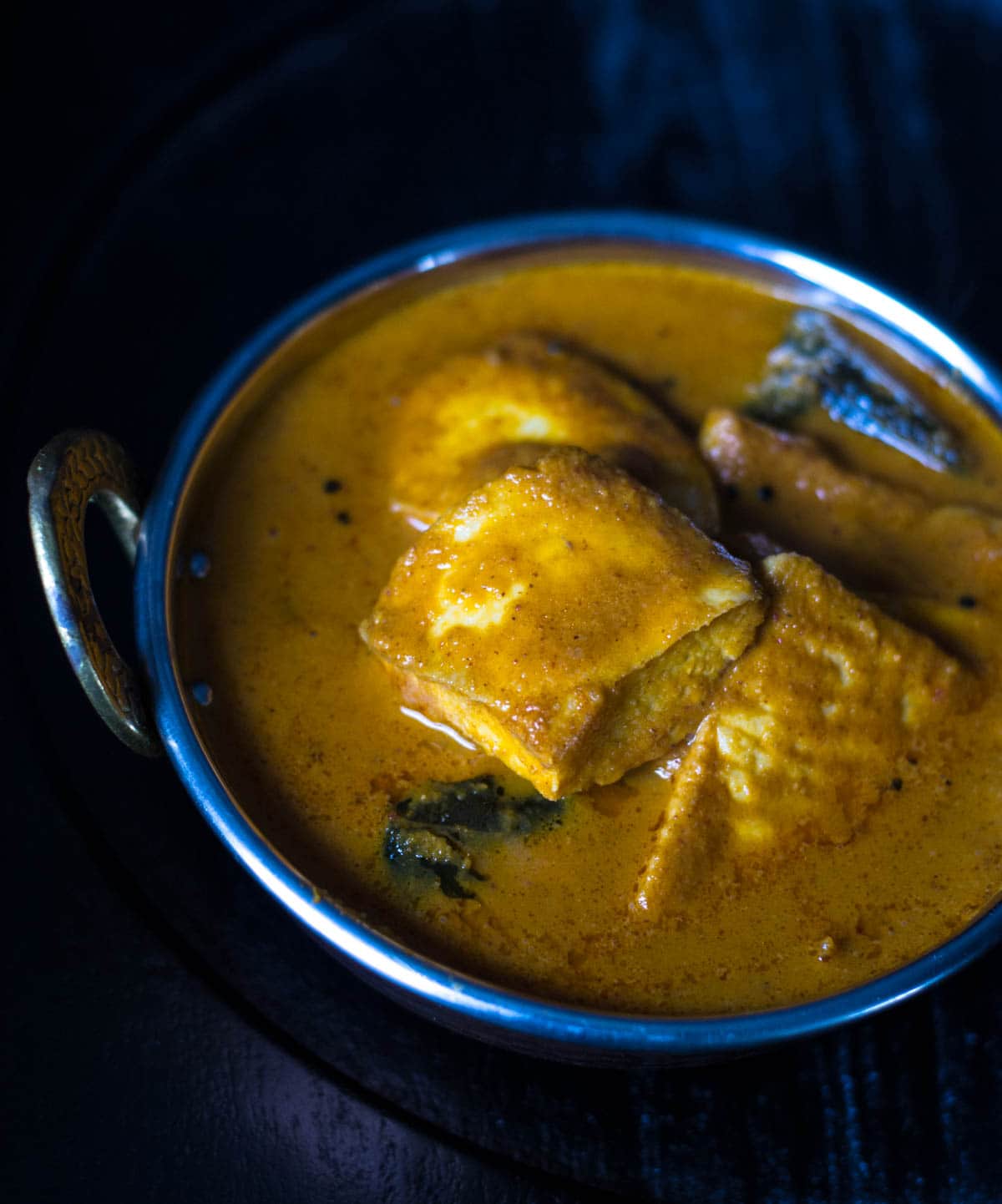 Meen gassi (fish curry) served in a metal bowl