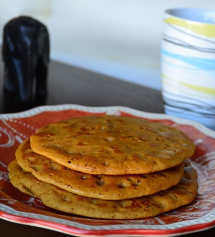 Sweet Cheela stacked in a red and white plate