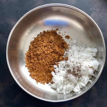 A steel bowl with coconut, cardamom powder and grated coconut