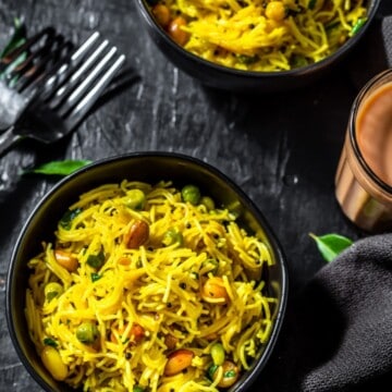 Lemon Semiya Upma served in a black bowl with a glass of tea