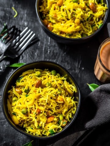 Lemon Semiya Upma served in a black bowl with a glass of tea