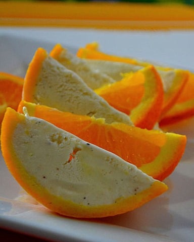 Orange wedge ice cream served on a white plate