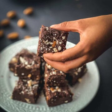 A hand holding a piece of microwave fudge