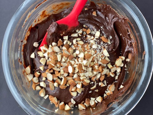 Chopped nuts added to chocolate mixture kept in a glass bowl