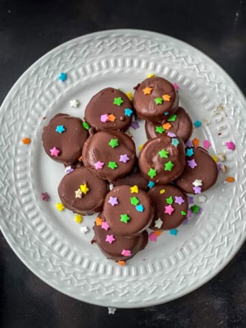 Frozen chocolate covered banana bites served on a white plate