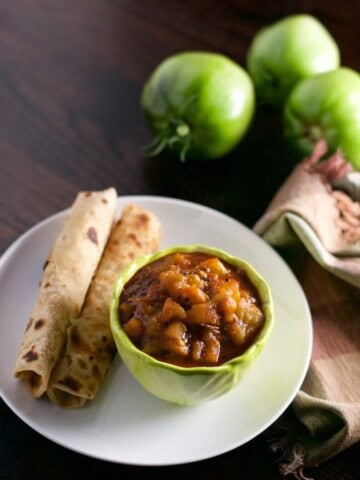 Hare tamatar ki sabzi served in a bowl with roti