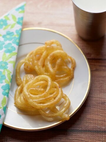 Jalebis placed on a white plate with a napkin on the left side