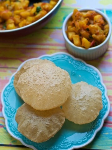 An overhead shot of pooris served with Aloo sabzi (Potato curry)