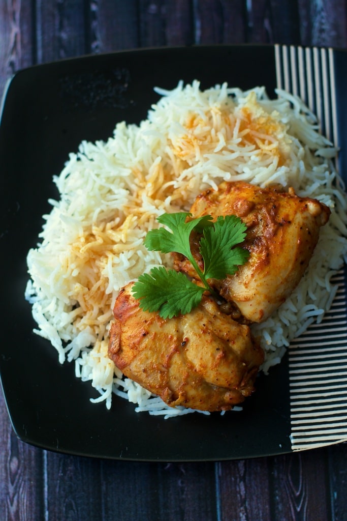 Mangalorean style baked chicken served on rice and garnished with cilantro