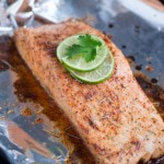 Baked salmon topped with sliced limes on aluminium foil 