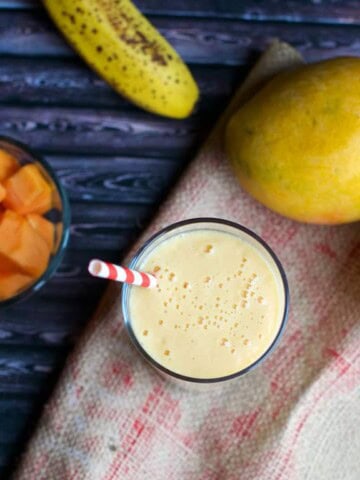 Papaya mango smoothie with a straw