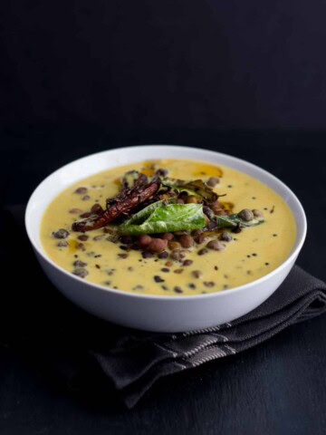 Kaale channe ki kadhi served in a white bowl placed over a brown napkin