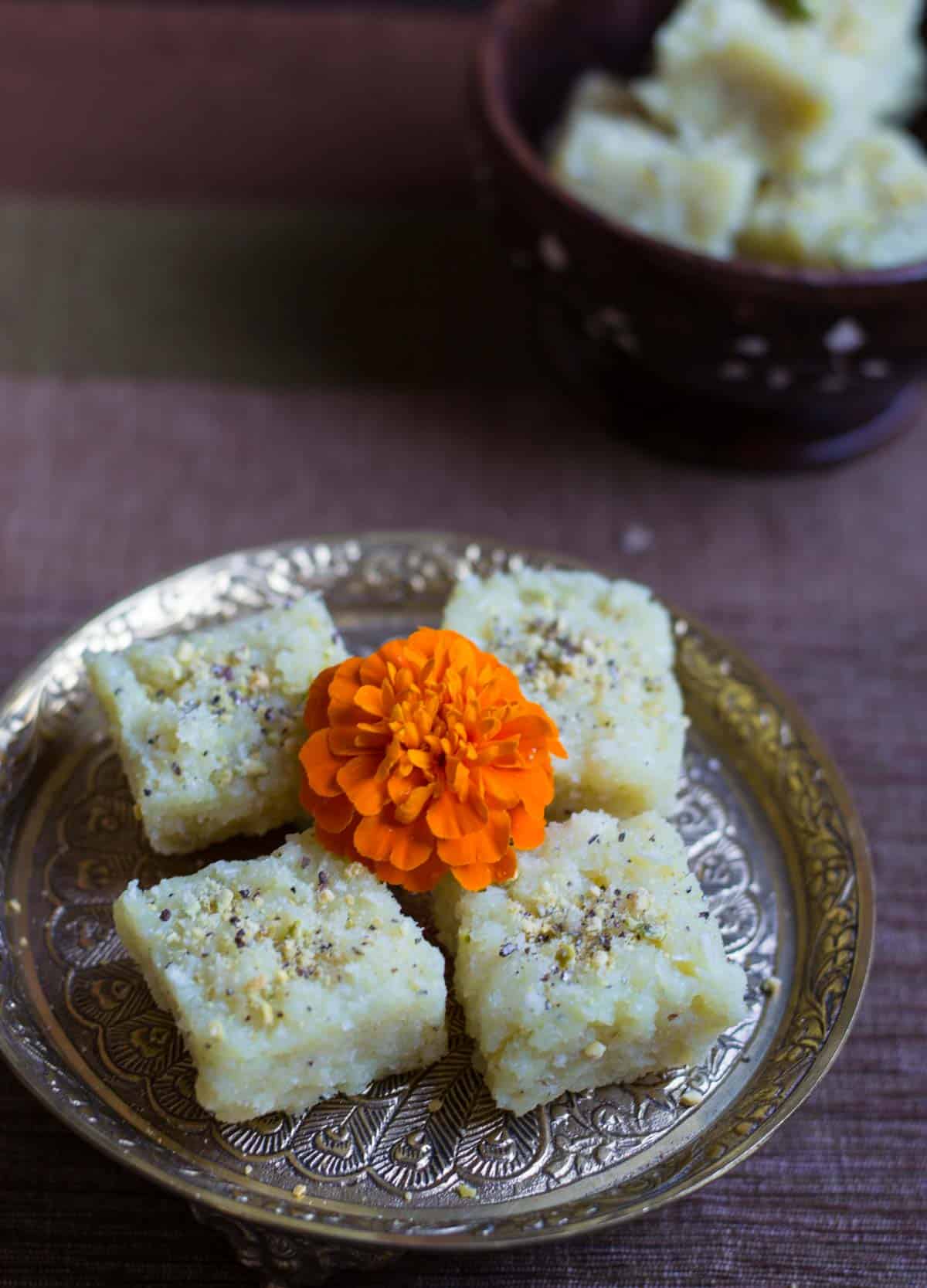 Coconut barfi served on a metal plate