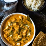 Paneer Makhani served in a white bowl garnished with fenugreek leaves
