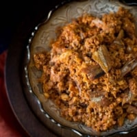 Dried fish chutney kept in a silver bowl placed over a wooden trivet