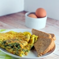 Omelette served with slices of brown bread in a white plate
