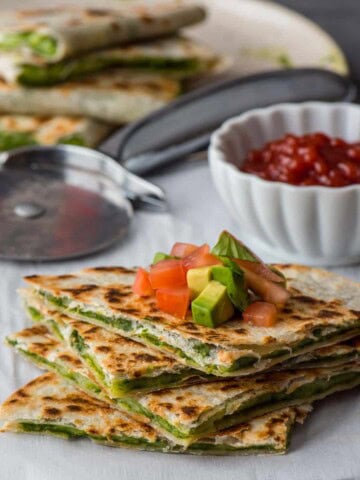 Stacked Chutney cheese quesadilla with chopped tomatoes and avocado on top