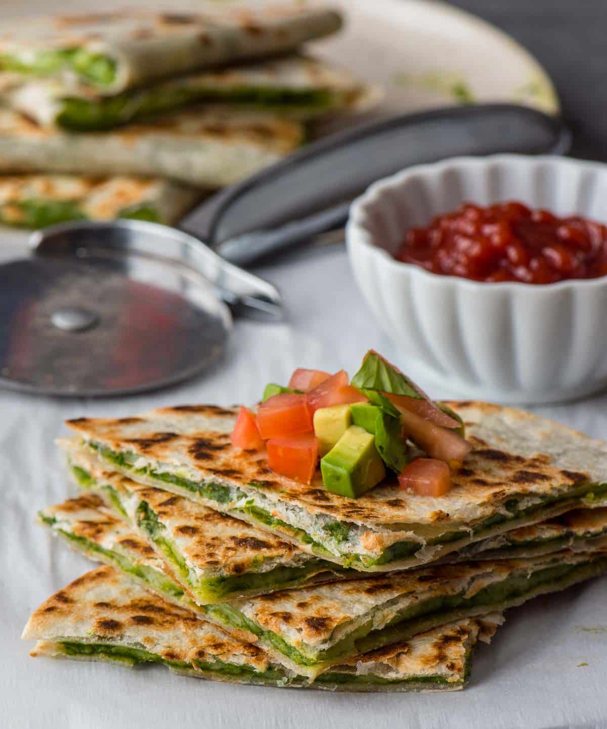 Stacked Chutney cheese quesadilla with chopped tomatoes and avocado on top