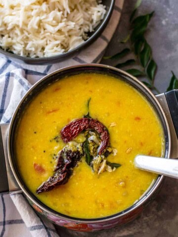 Tadka dal served in a black bowl along with rice