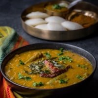 Sambar served in a black bowl. Idli served with sambar.