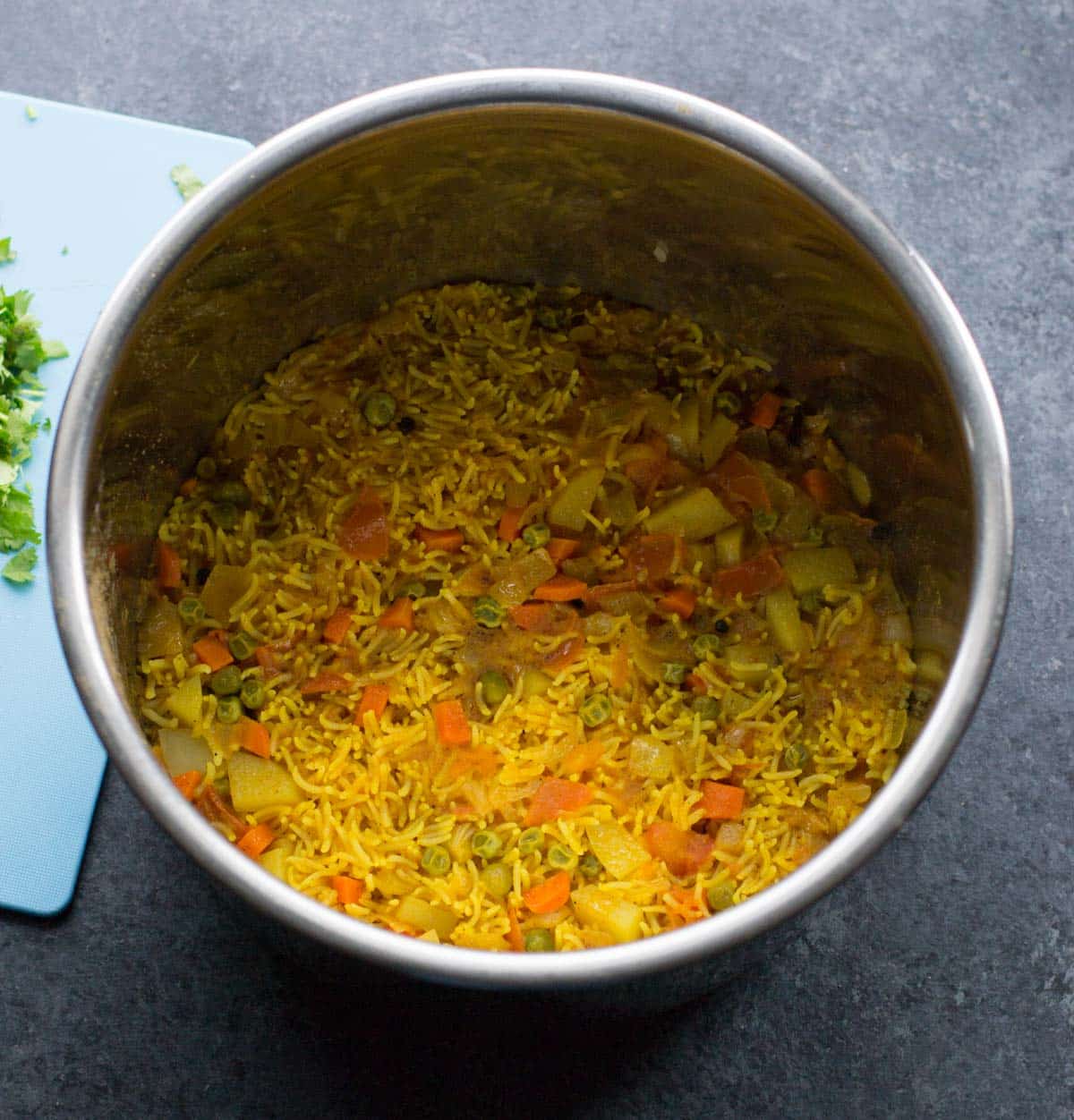 Instant Pot Vegetable biryani cooked in an Instant Pot and with coriander leaves on a chopping board