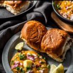 Pav bhaji served with a silver of butter, finely chopped onions, crispy pav and lemon wedges