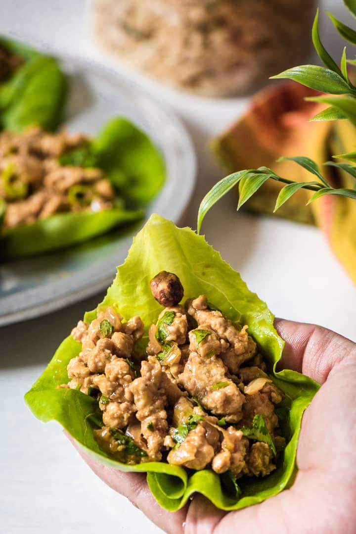 A hand holding lettuce wraps