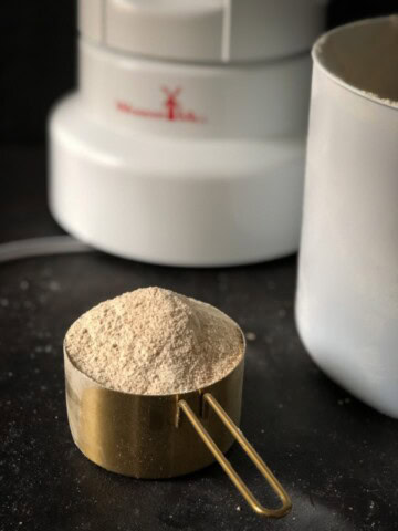 A cup of Homemade Whole Wheat flour in a measuring cup.