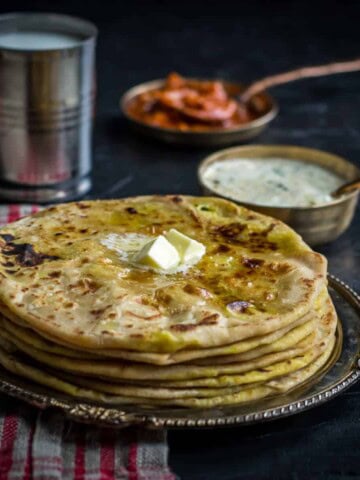 Aloo paratha served with raita, pickle and lassi