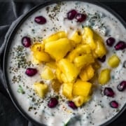 An overhead shot of pineapple raita topped with pomegranate seeds