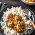 Dum aloo served with rice in a black plate