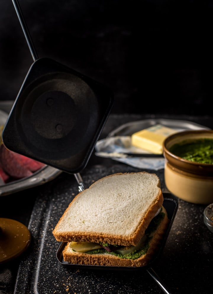 An assembled Bombay Sandwich is placed in a stove top sandwich maker