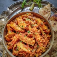 paneer jalfrezi garnished with cilantro in a silver bowl