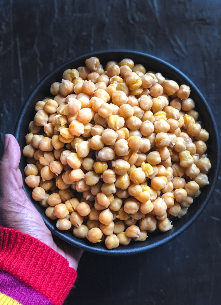An overhead shot of chickpeas in a black bowl