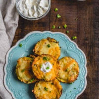 An overhead shot of leftover mashed potato muffins stacked on a blue plate