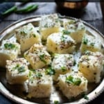 Square shaped pieces of rava dhokla served in a steel plate