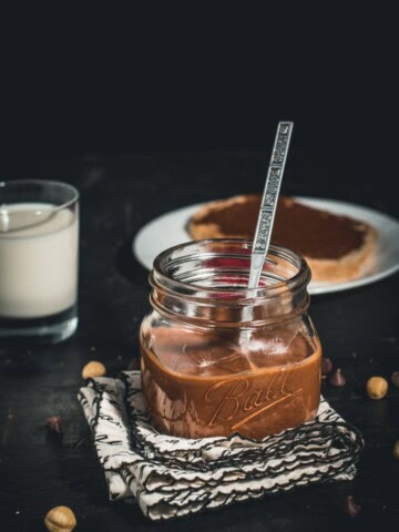 A glass jar filled with chocolate hazelnut spread