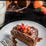 A white plate with a slice of instant pot brownies topped with strawberries with the words Instant Pot Made from Scratch Brownies at the top.