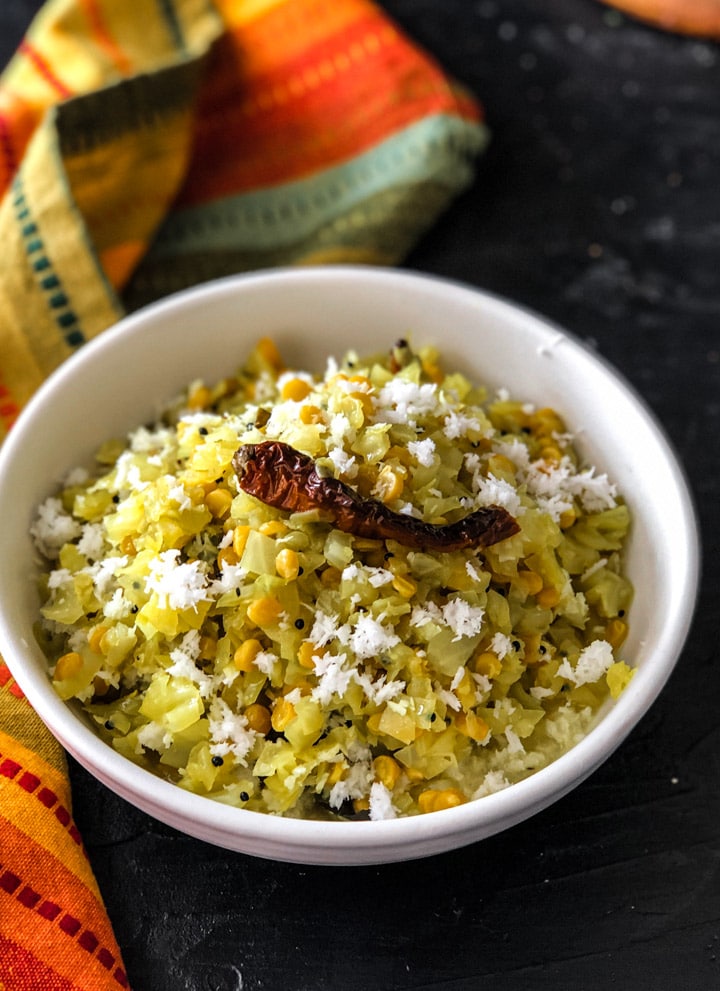 Cabbage Kootu served in white bowl topped with red chily and grated coconut