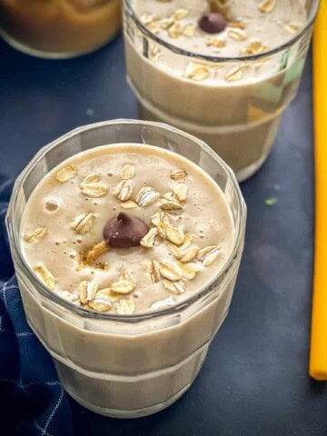 Peanut Butter Banana smoothie served in a glass topped with chocolate chip morsels and rolled oats
