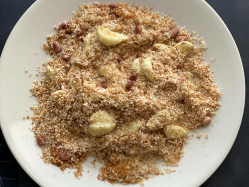 Roasted Garlic cloves, desiccated coconut, sesame seeds and peanuts in a plate
