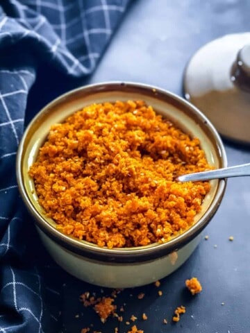 An overhead shot of garlic chutney served in a brown ceramic bowl