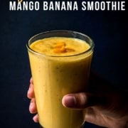 A hand holding a glass of Mango Banana Smoothie