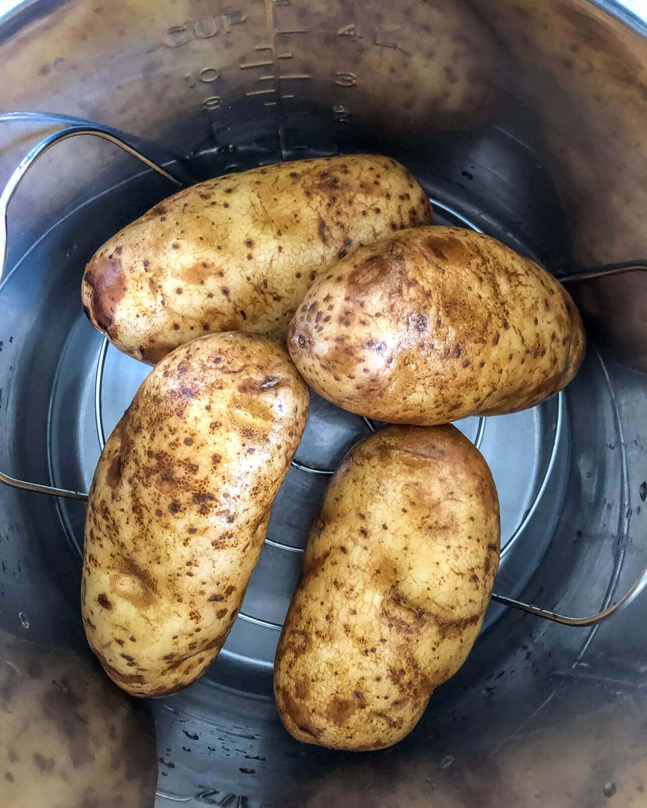 Four potatoes in the instant pot before cooking.