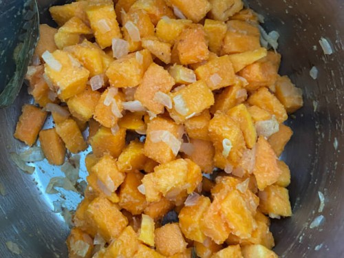 The instant pot with butternut squash cubes tossed with the aromatics.