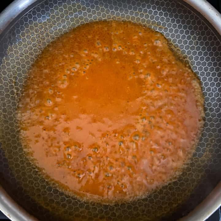Buffalo sauce melting in a pan.
