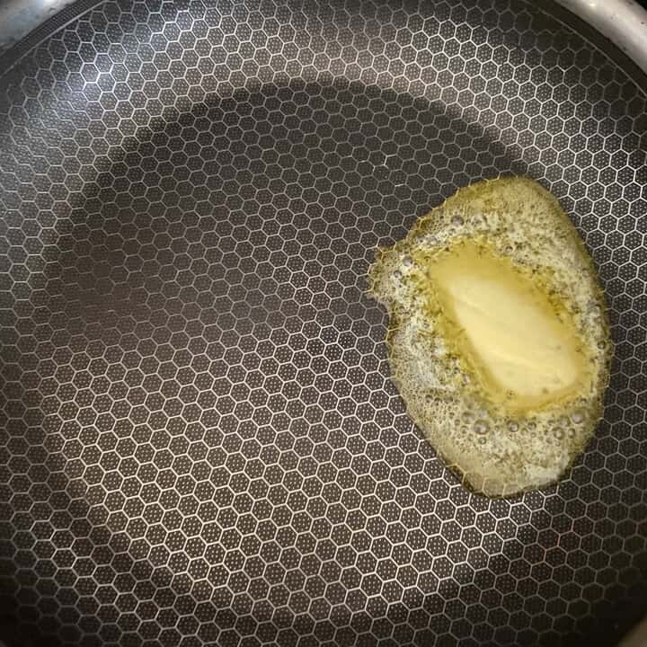 Butter melting in a non-stick skillet.
