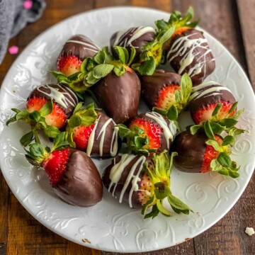 A white plate with chocolate dipped strawberries filling the plate.
